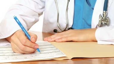 Young female doctor at desk isolated on white background